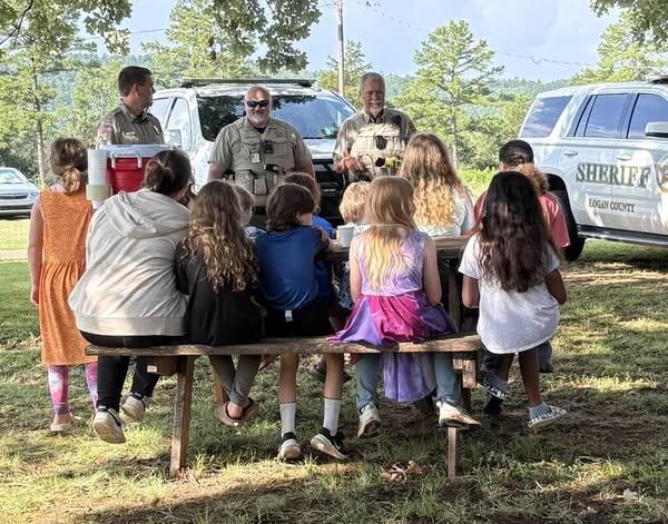 Photo of Sheriff and Deputies speaking with kids.